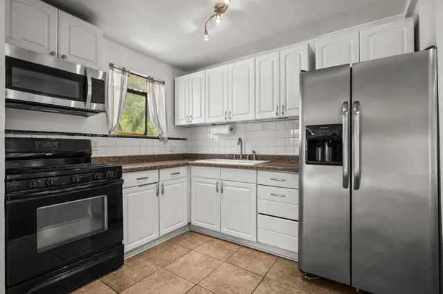 a kitchen with cabinets stainless steel appliances and a counter space