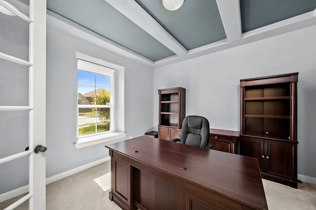 a view of a workspace with furniture and a window