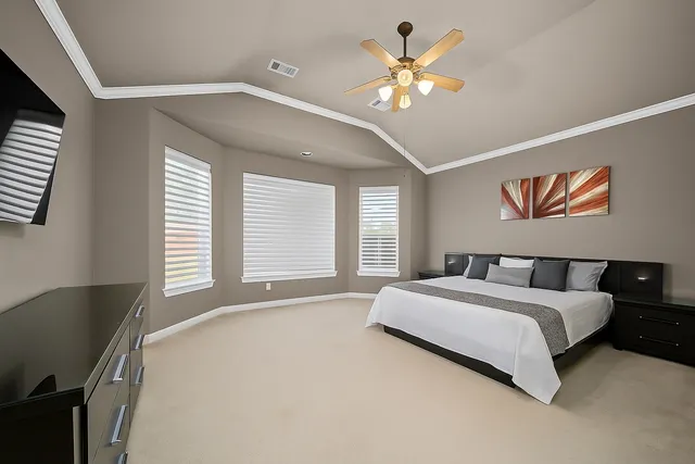 a spacious bedroom with a bed and a chandelier