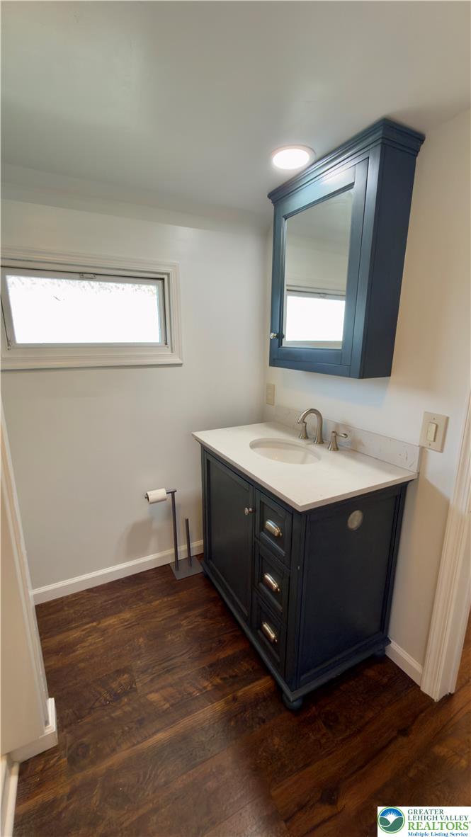 246 Poplar Street Bath, PA 18014 - Photo 33 of 34 A well-appointed powder room features rich hardwood flooring and a stylish dark vanity.