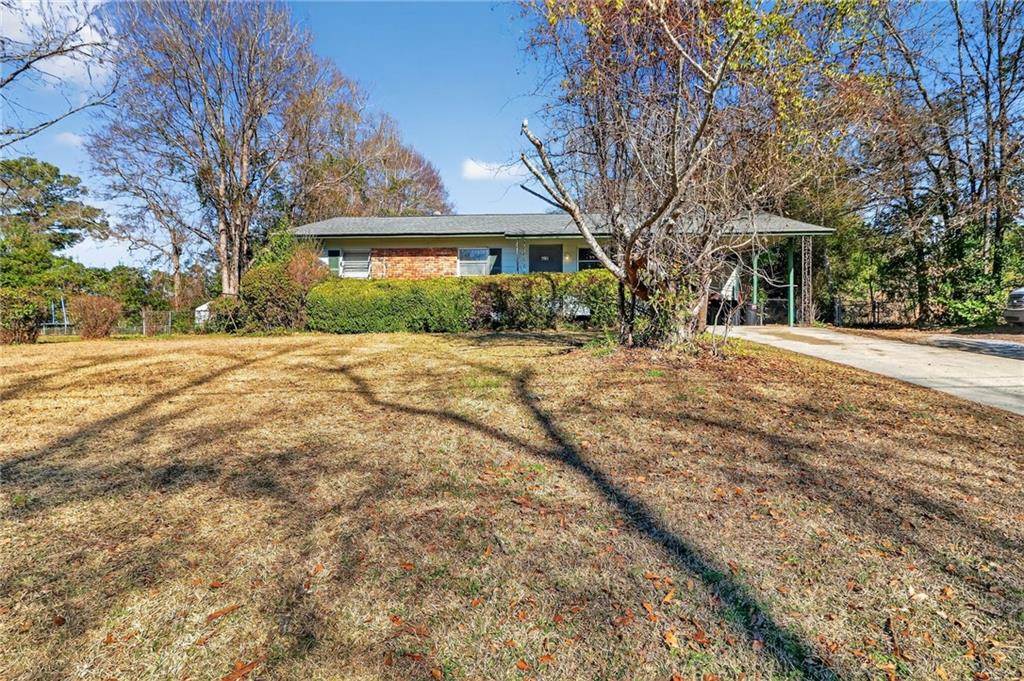 a front view of a house with a yard and trees