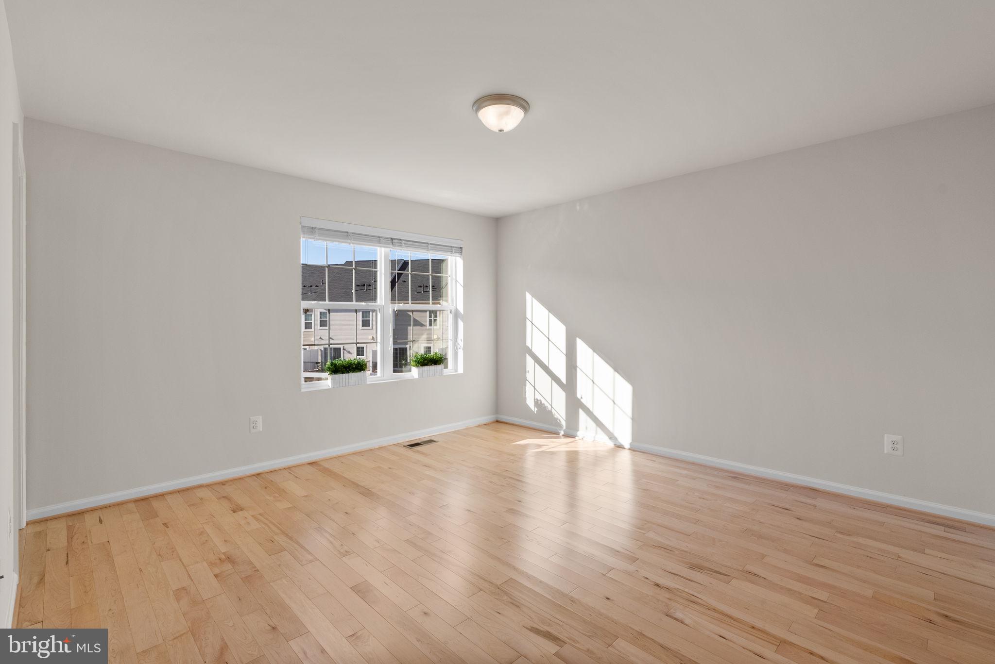 8012 Alchemy Way Elkridge, MD 21075 - Photo 20 of 46 a view of an empty room with wooden floor and a window