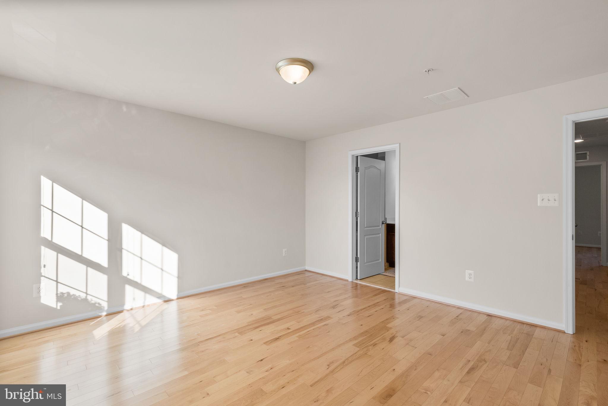 8012 Alchemy Way Elkridge, MD 21075 - Photo 21 of 46 a view of an empty room with wooden floor and windows