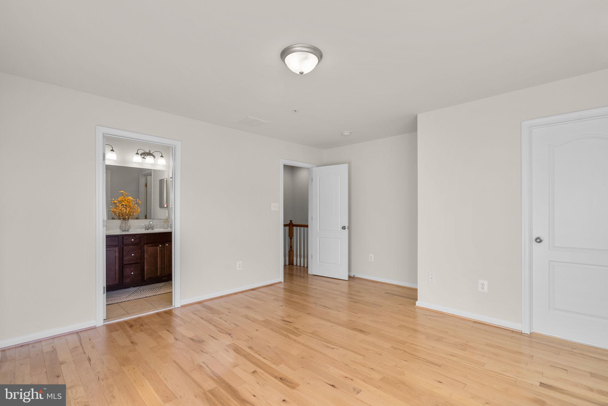 8012 Alchemy Way Elkridge, MD 21075 - Photo 22 of 46 a view of an empty room with wooden floor and a window