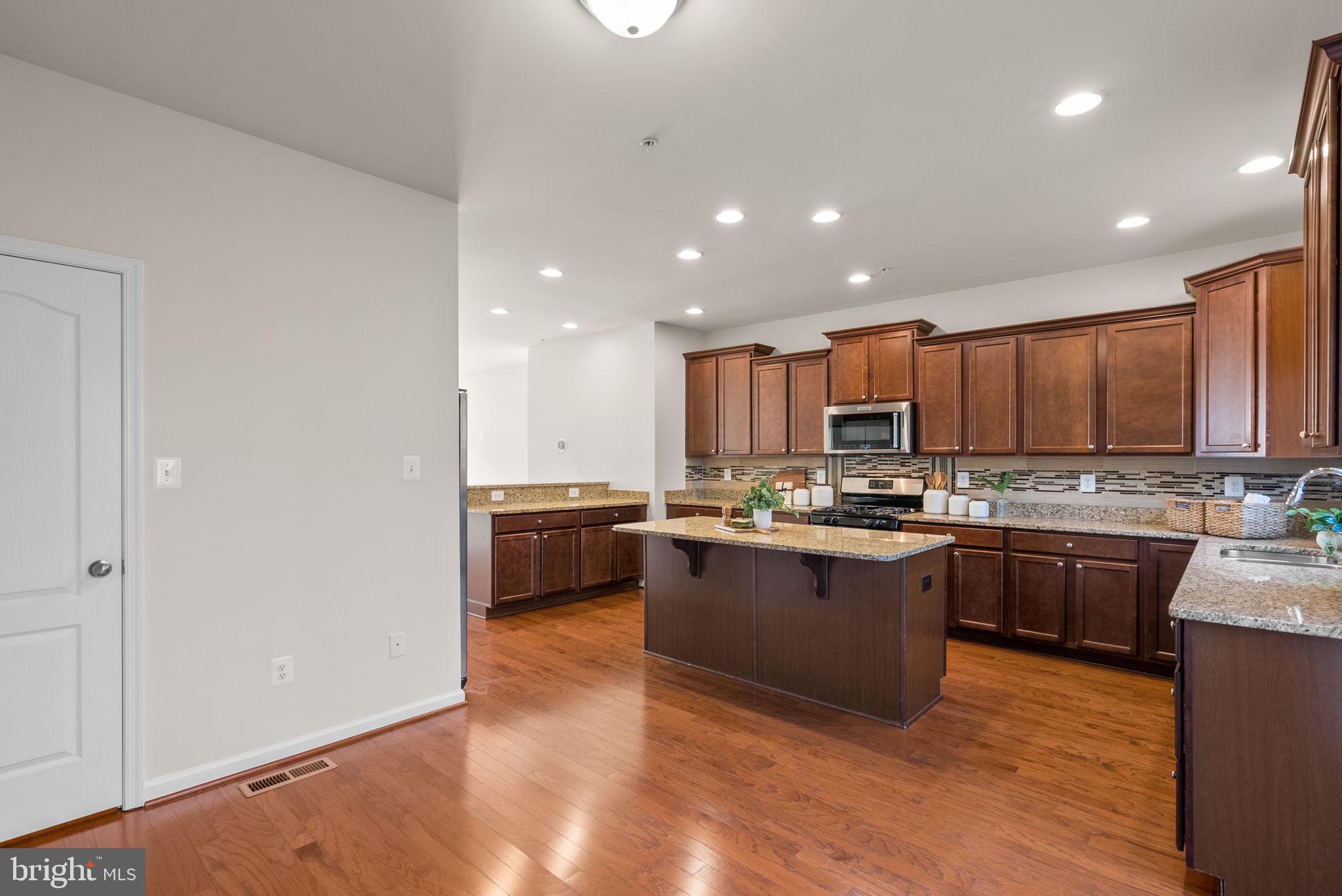 8012 Alchemy Way Elkridge, MD 21075 - Photo 10 of 46 a kitchen with stainless steel appliances granite countertop a stove a sink and a refrigerator