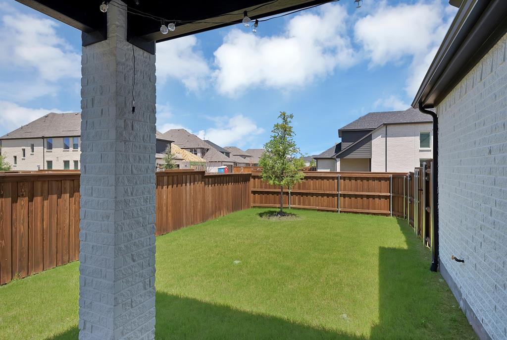 5012 Triadic Lane Prosper, TX 75078 - Photo 34 of 38 Expansive backyard featuring a manicured lawn, a young tree, and a tall wood privacy fence
