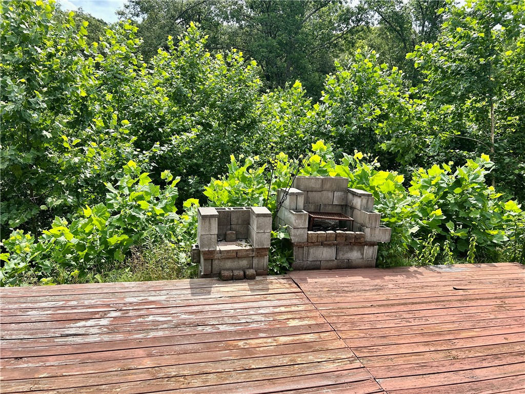 462789 East 820 Road Stilwell, OK 74960 - Photo 23 of 48 Wood deck with a natural finish, surrounded by lush green foliage
