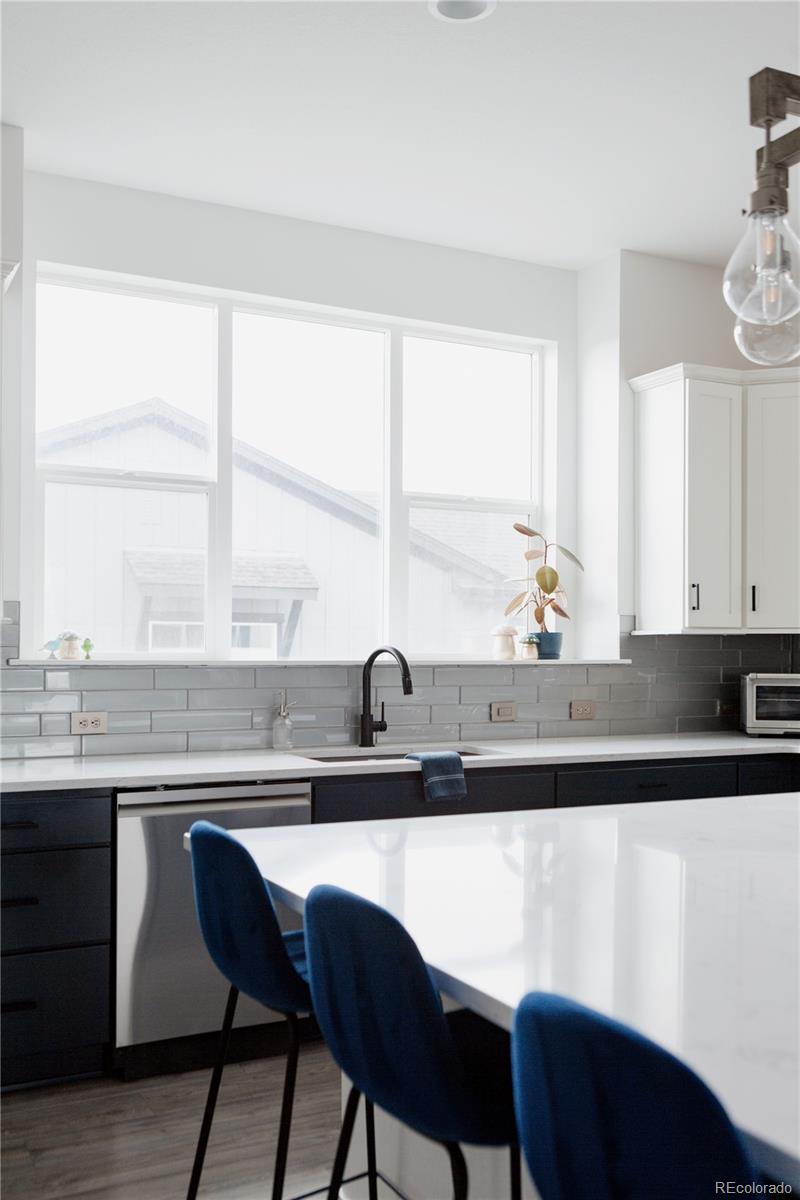 11890 West 52nd Avenue Wheat Ridge, CO 80033 - Photo 12 of 44 a kitchen with a sink a window and chairs