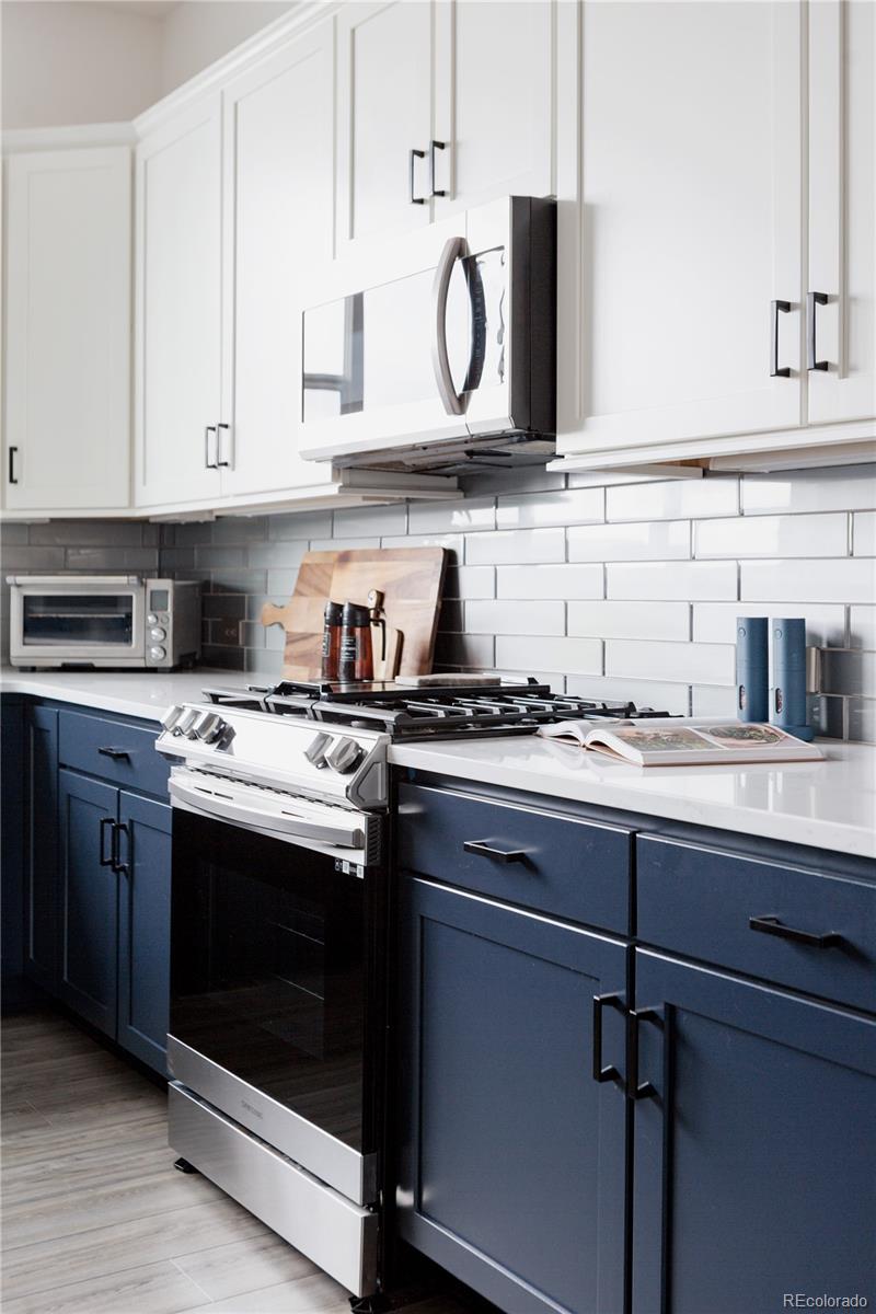 11890 West 52nd Avenue Wheat Ridge, CO 80033 - Photo 13 of 44 a kitchen with stainless steel appliances granite countertop a sink and cabinets