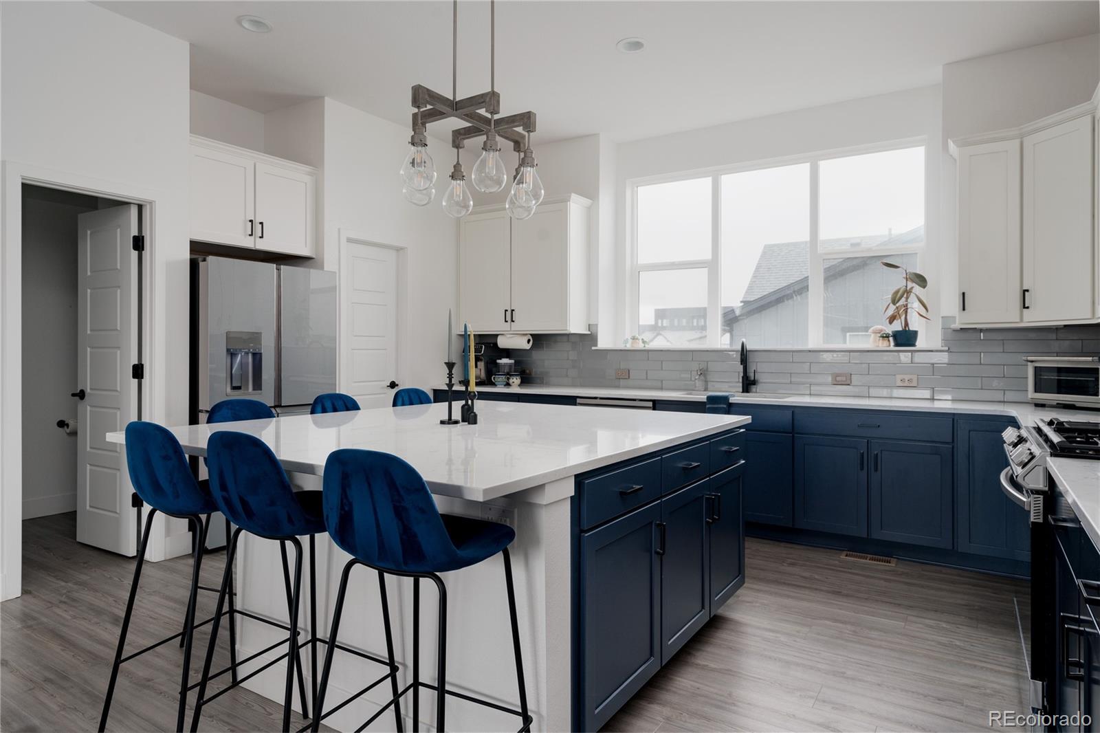 11890 West 52nd Avenue Wheat Ridge, CO 80033 - Photo 16 of 44 a kitchen with a table chairs sink and cabinets