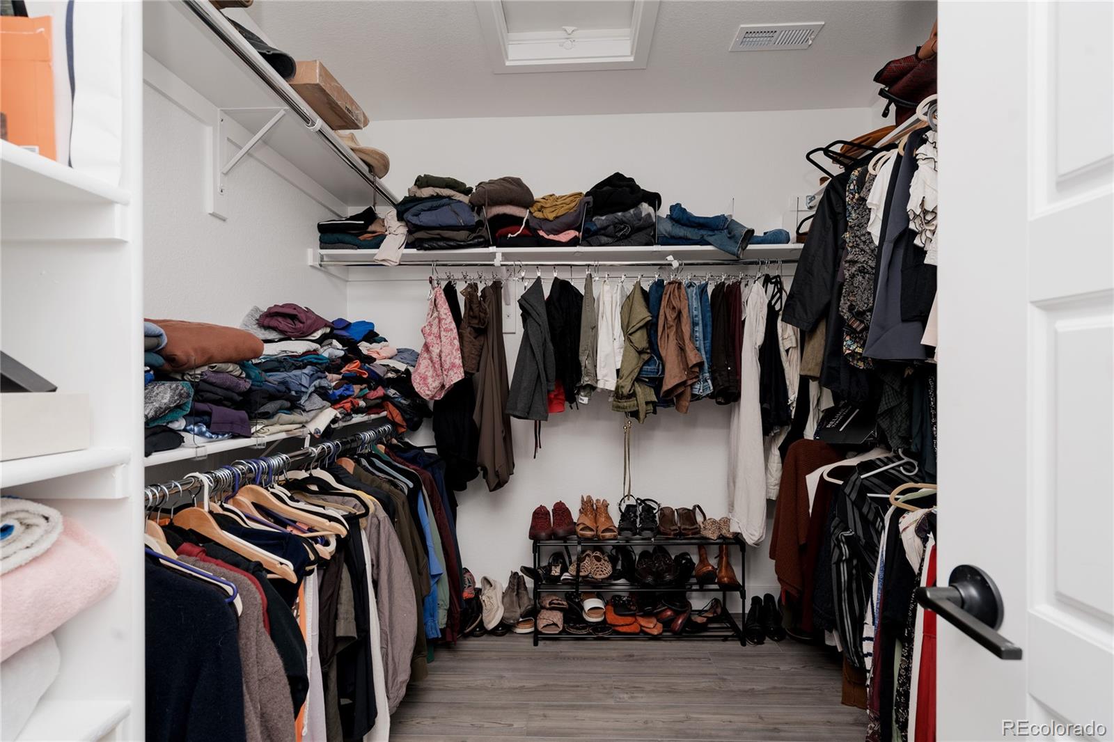 11890 West 52nd Avenue Wheat Ridge, CO 80033 - Photo 33 of 44 a view of walk in closet with clothes and shoes