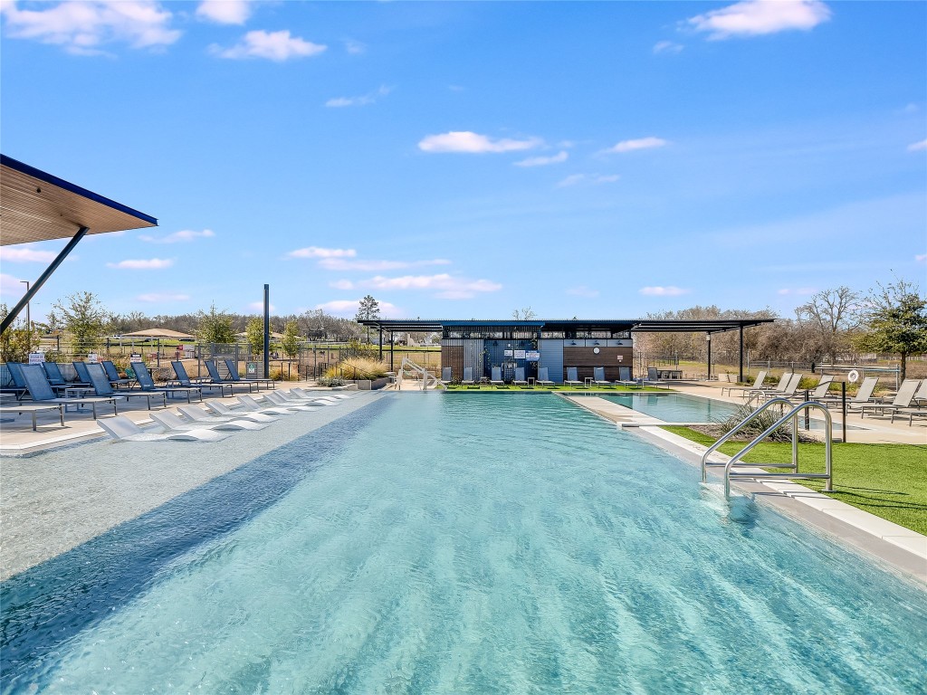 7401 Grand Linden Way, Unit 78 Austin, TX 78744 - Photo 14 of 17 a view of a swimming pool with an outdoor seating and a garden