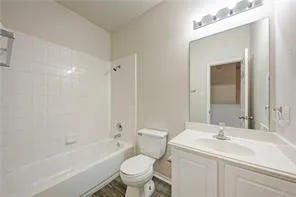a bathroom with a toilet a sink a mirror a bathtub and vanity