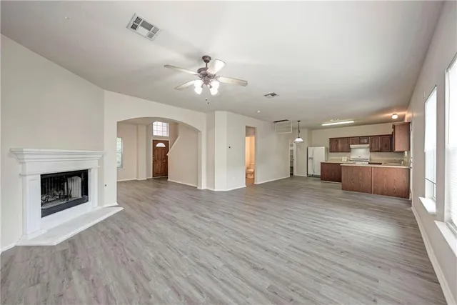 a view of a kitchen with furniture a ceiling fan and wooden floor