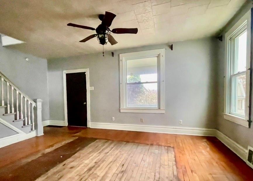 424 Ridge Avenue New Kensington, PA 15068 - Photo 4 of 15 an empty room with wooden floor a ceiling fan and windows