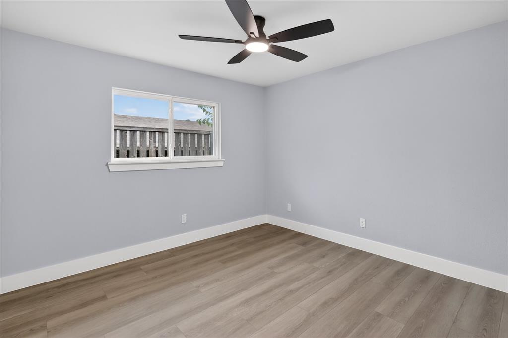 2005 Chestnut Road Carrollton, TX 75007 - Photo 16 of 35 a view of an empty room with wooden floor and a ceiling fan