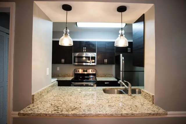 a kitchen with a refrigerator and a counter top space