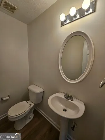 a bathroom with a toilet a sink and a mirror