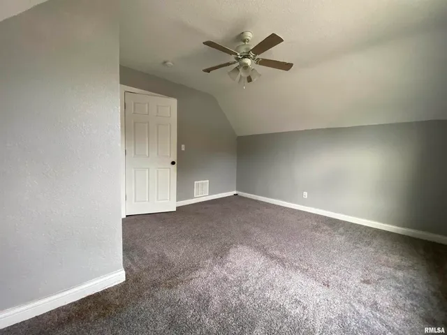 an empty room with a ceiling fan and a window