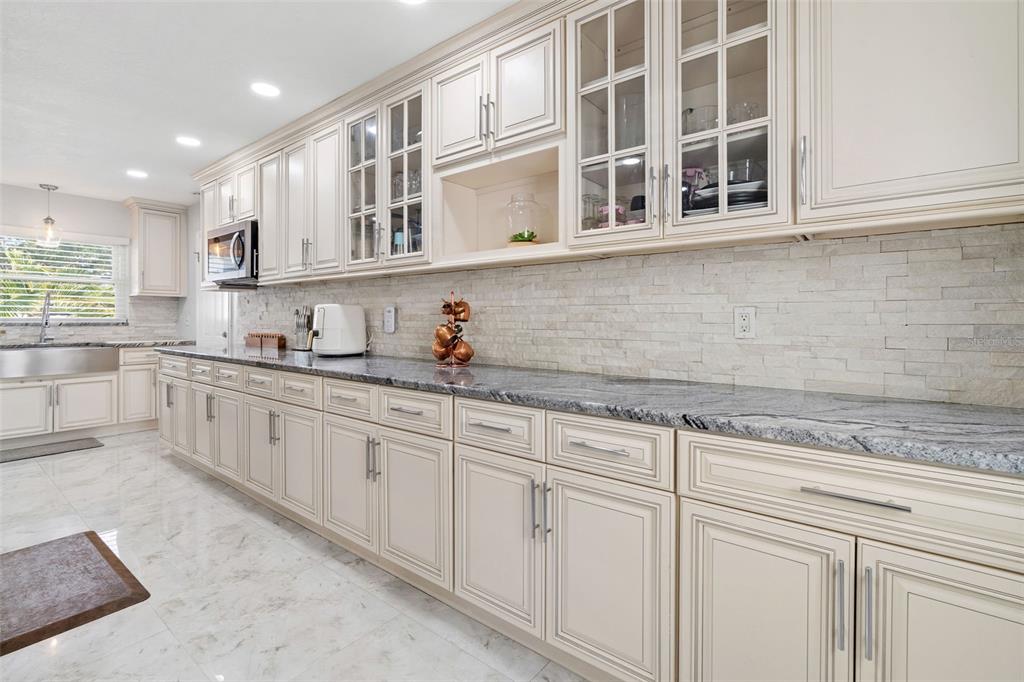 2453 Roberta Street Largo, FL 33771 - Photo 12 of 29 a kitchen with stainless steel appliances granite countertop white cabinets and sink