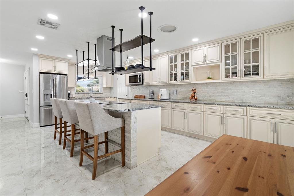 2453 Roberta Street Largo, FL 33771 - Photo 13 of 29 a kitchen with kitchen island a sink table and chairs