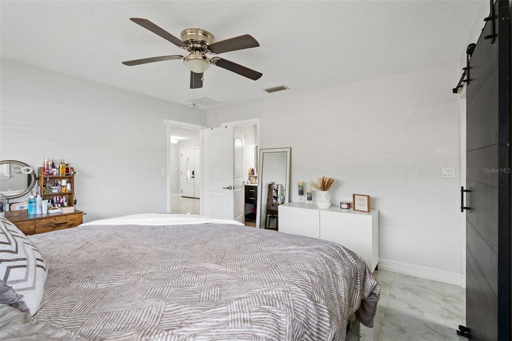 2453 Roberta Street Largo, FL 33771 - Photo 15 of 29 a bedroom with a bed and a chandelier