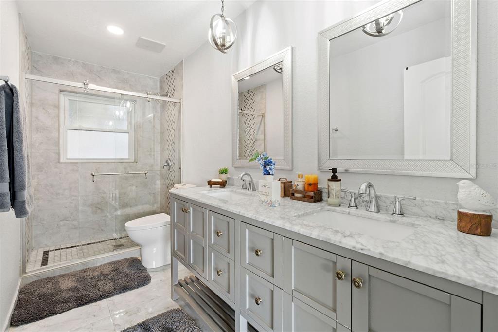 2453 Roberta Street Largo, FL 33771 - Photo 20 of 29 a bathroom with a double vanity sink a toilet and a mirror