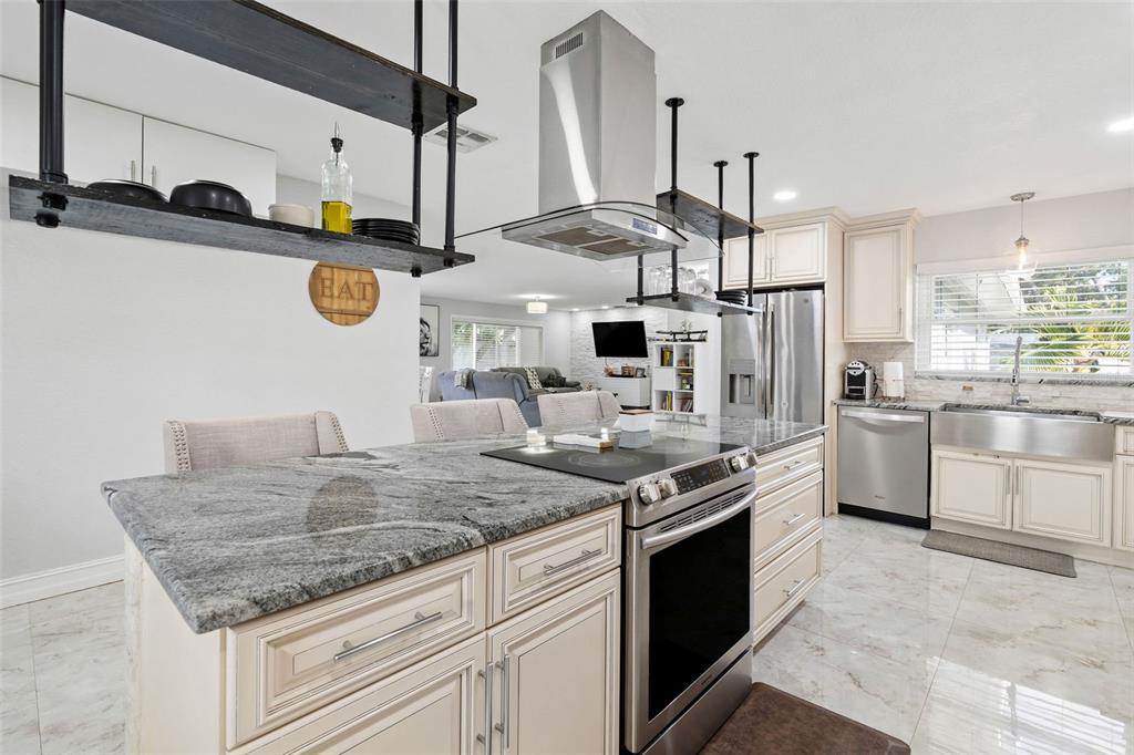 2453 Roberta Street Largo, FL 33771 - Photo 10 of 29 a kitchen with stainless steel appliances granite countertop a sink a stove and a refrigerator