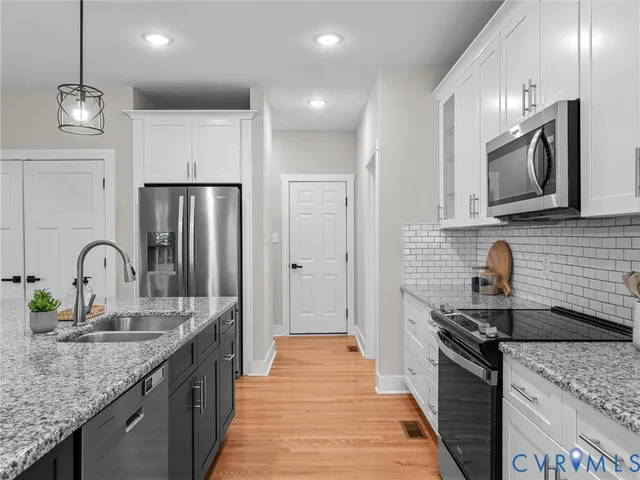 a large kitchen with stainless steel appliances kitchen island granite countertop a large center island and a sink