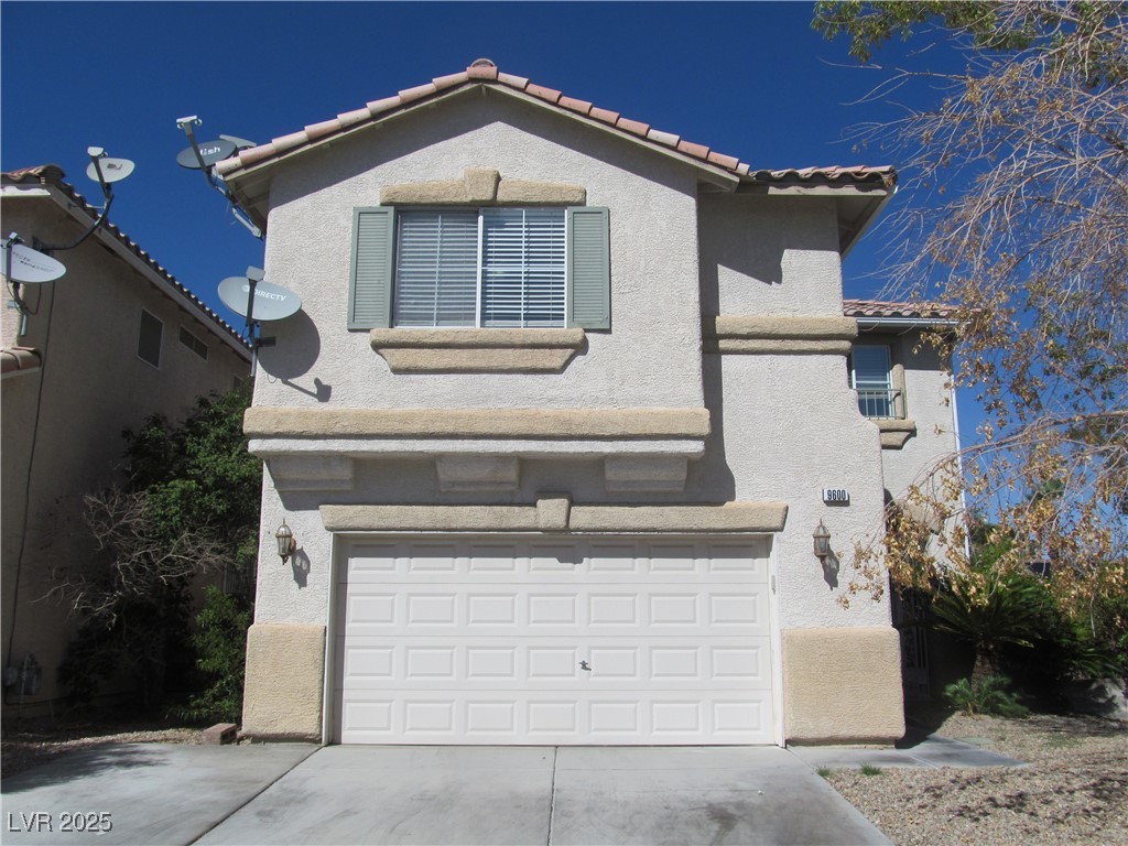 Mediterranean / spanish-style home with a tiled roof, stucco siding, driveway, and an attached garage