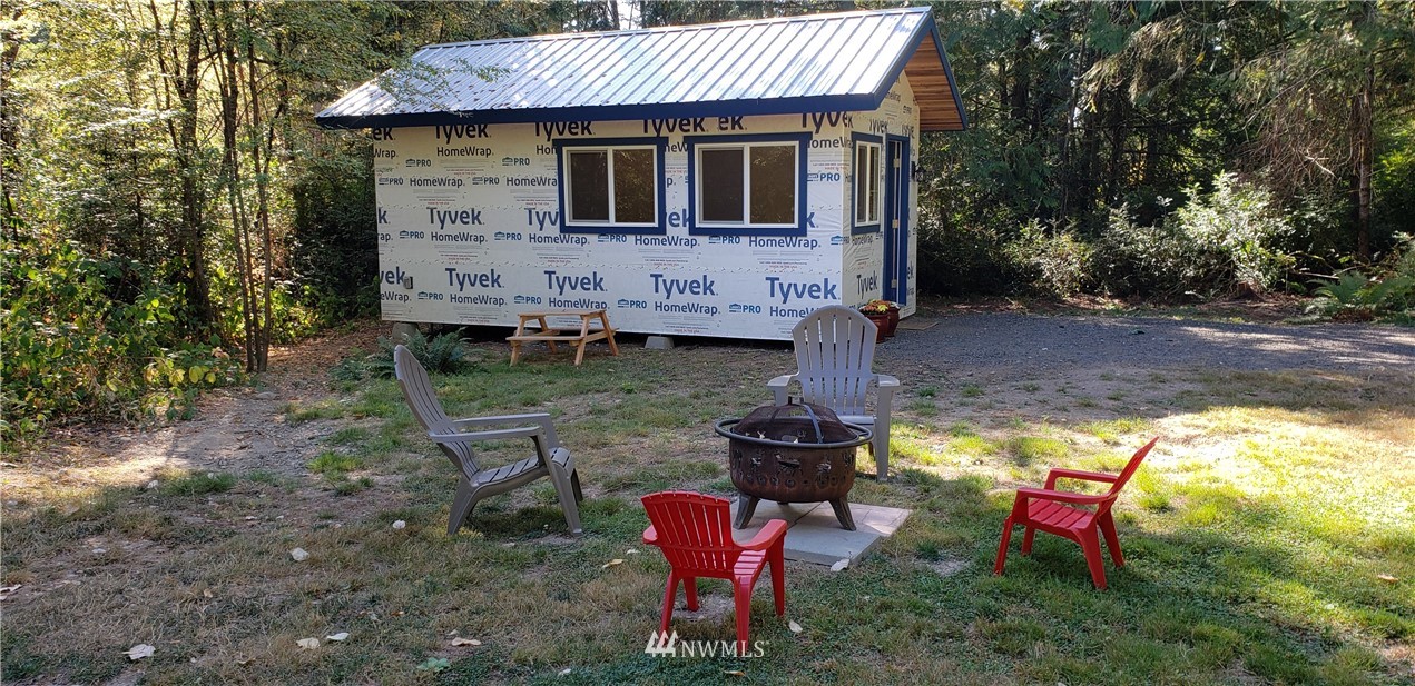 17613 Rouse Road Southwest Longbranch, WA 98351 - Photo 1 of 38 a backyard of a house with fountain table and chairs