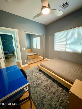 a bedroom with a bed and a flat tv screen on dresser