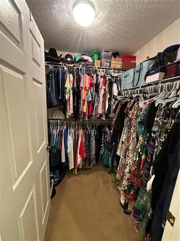 a view of walk in closet with clothes