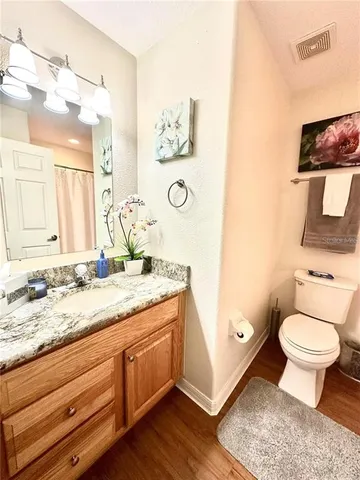 a bathroom with a granite countertop toilet sink and mirror