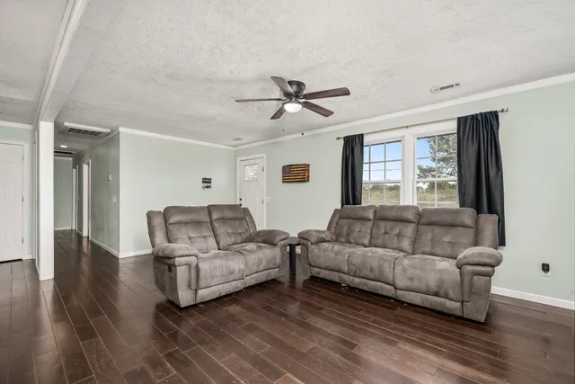 a kitchen with stainless steel appliances kitchen island granite countertop a table chairs and a refrigerator