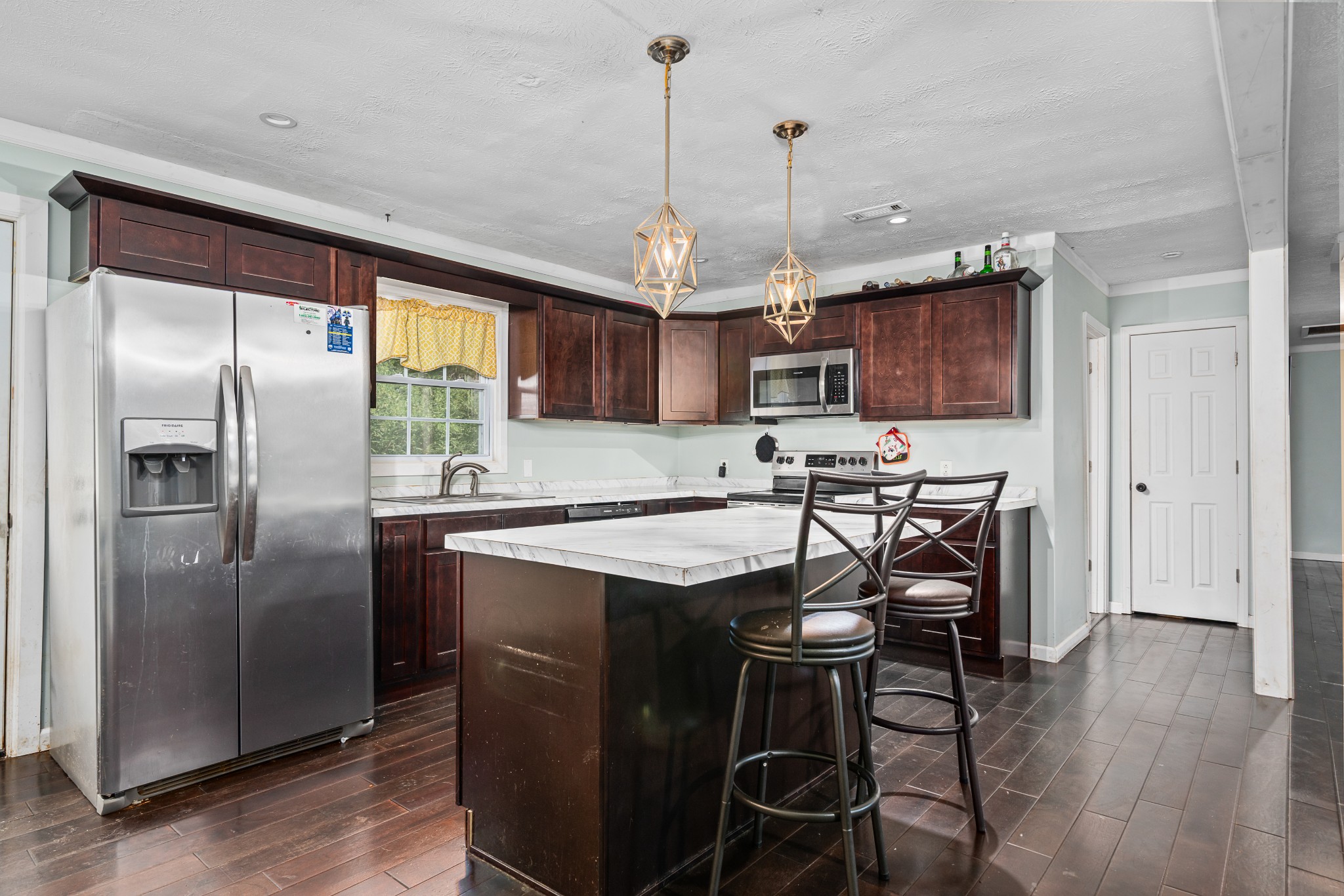4871 New Window Cliff Road Baxter, TN 38544 - Photo 8 of 26 a kitchen with stainless steel appliances granite countertop a stove top oven a refrigerator a sink and a center island