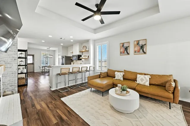 a living room with furniture and a wooden floor