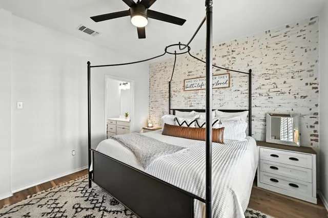 a bedroom with a bed and a lamp on the dresser