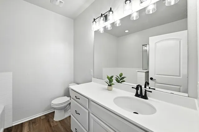 a bathroom with a sink vanity granite and toilet