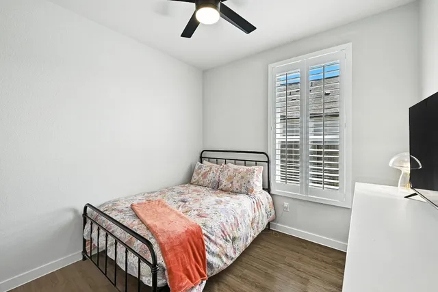 a bedroom with a bed a flat screen tv and a window