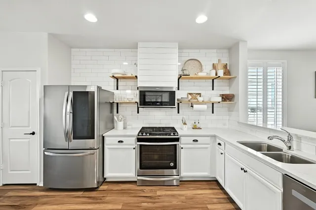 a kitchen with stainless steel appliances a stove sink and refrigerator