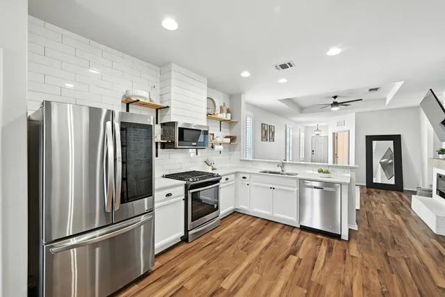 a kitchen with stainless steel appliances a refrigerator sink and microwave