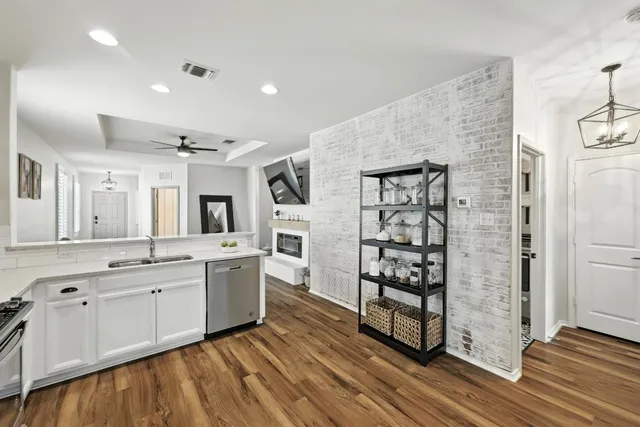 a large kitchen with lot of cabinets and wooden floor