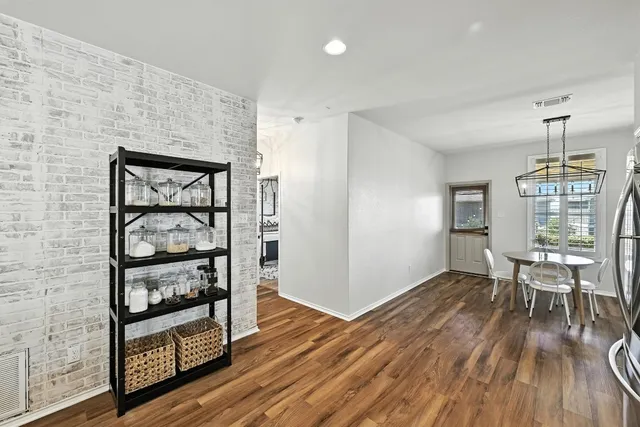 an empty room with wooden floor table and chairs