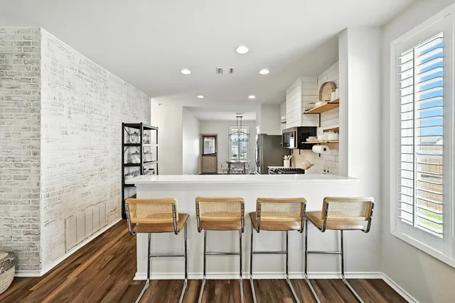 a kitchen with granite countertop cabinets and chair