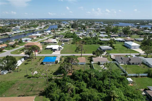an aerial view of residential houses with outdoor space and lake view