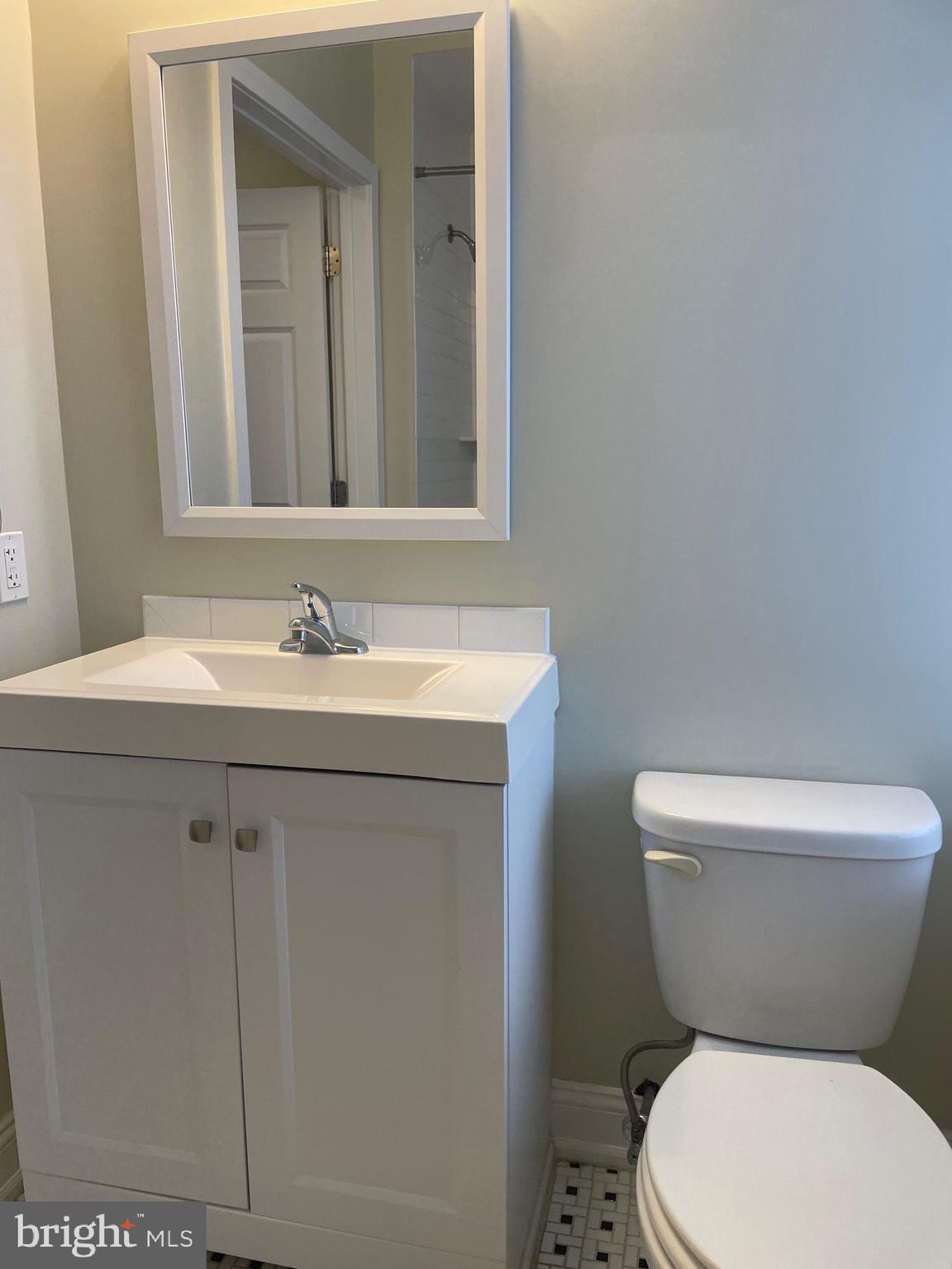 306 Cooper Street, Unit 302 Camden, NJ 08102 - Photo 15 of 21 a bathroom with a toilet sink and mirror