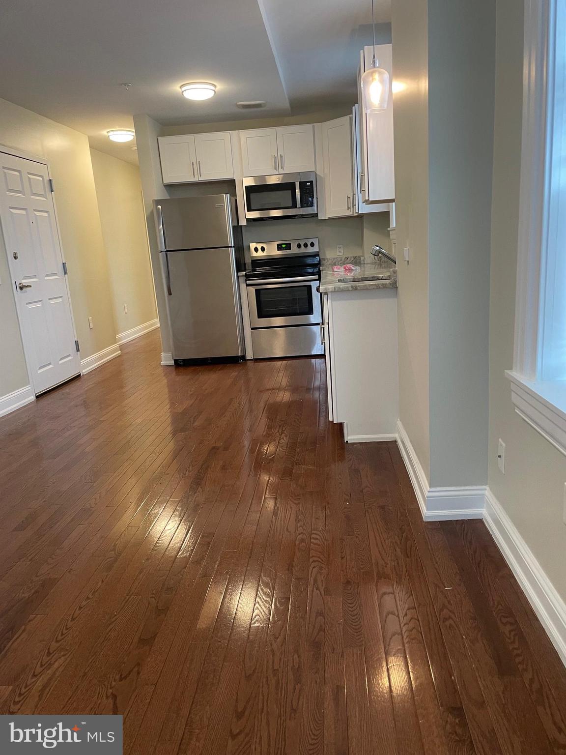 306 Cooper Street, Unit 302 Camden, NJ 08102 - Photo 6 of 21 a kitchen with a refrigerator and a stove top oven