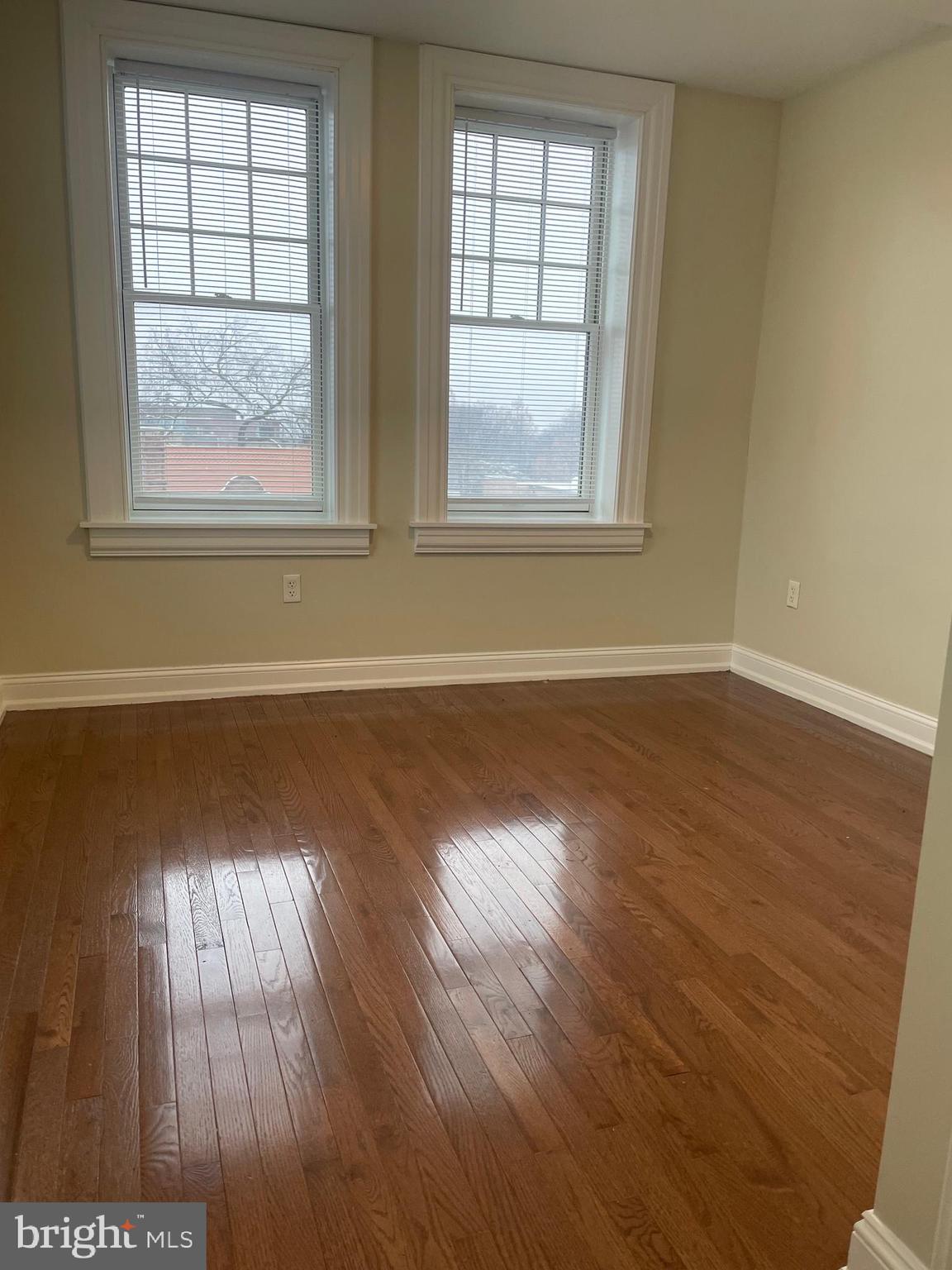 306 Cooper Street, Unit 302 Camden, NJ 08102 - Photo 9 of 21 an empty room with wooden floor and windows