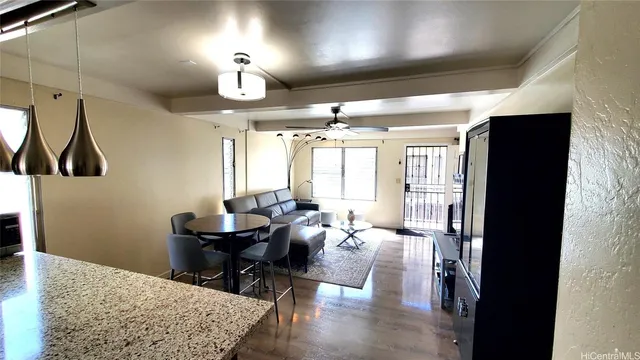 a living room with couches a dining table and chairs with wooden floor
